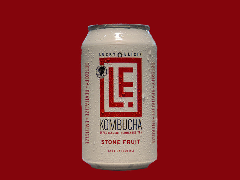 A can of Stone Fruit Kombucha with the brand Lucky Elixir visible on the label, against a red background.
